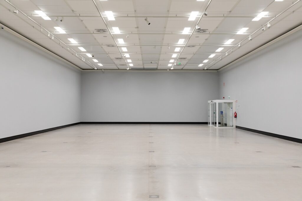 A light interior space with grey walls and bright ceiling lights.
